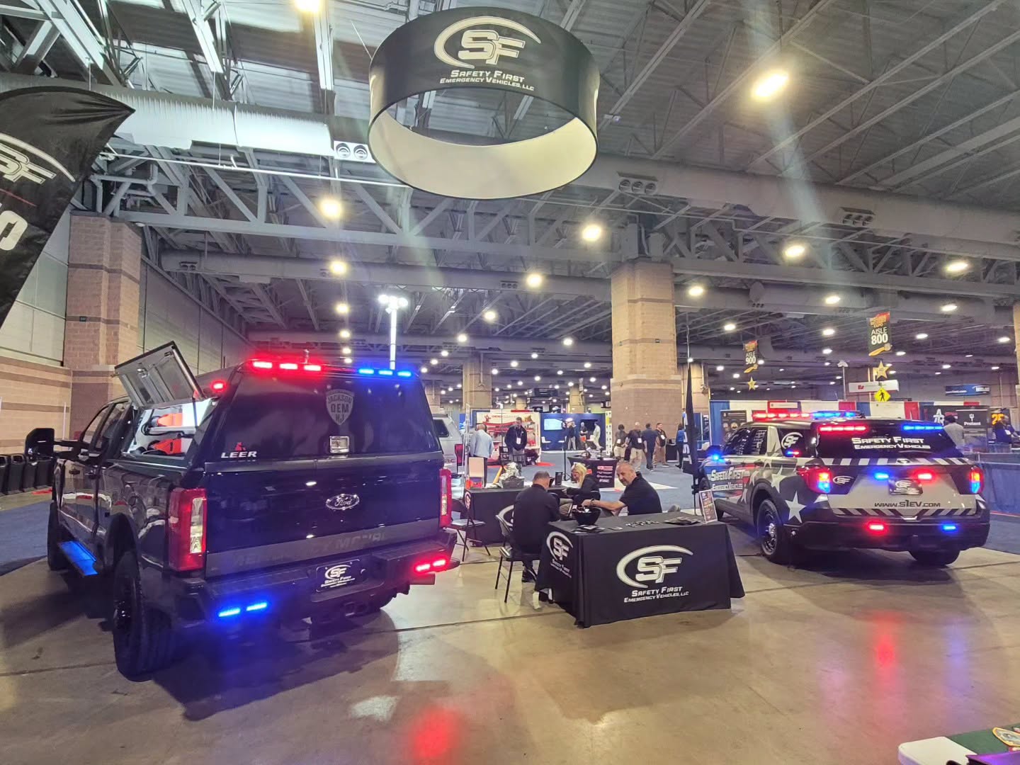 The SafetyFirst booth with the Ford Super Duty and Police Interceptor Utility flanking the staffed display table.